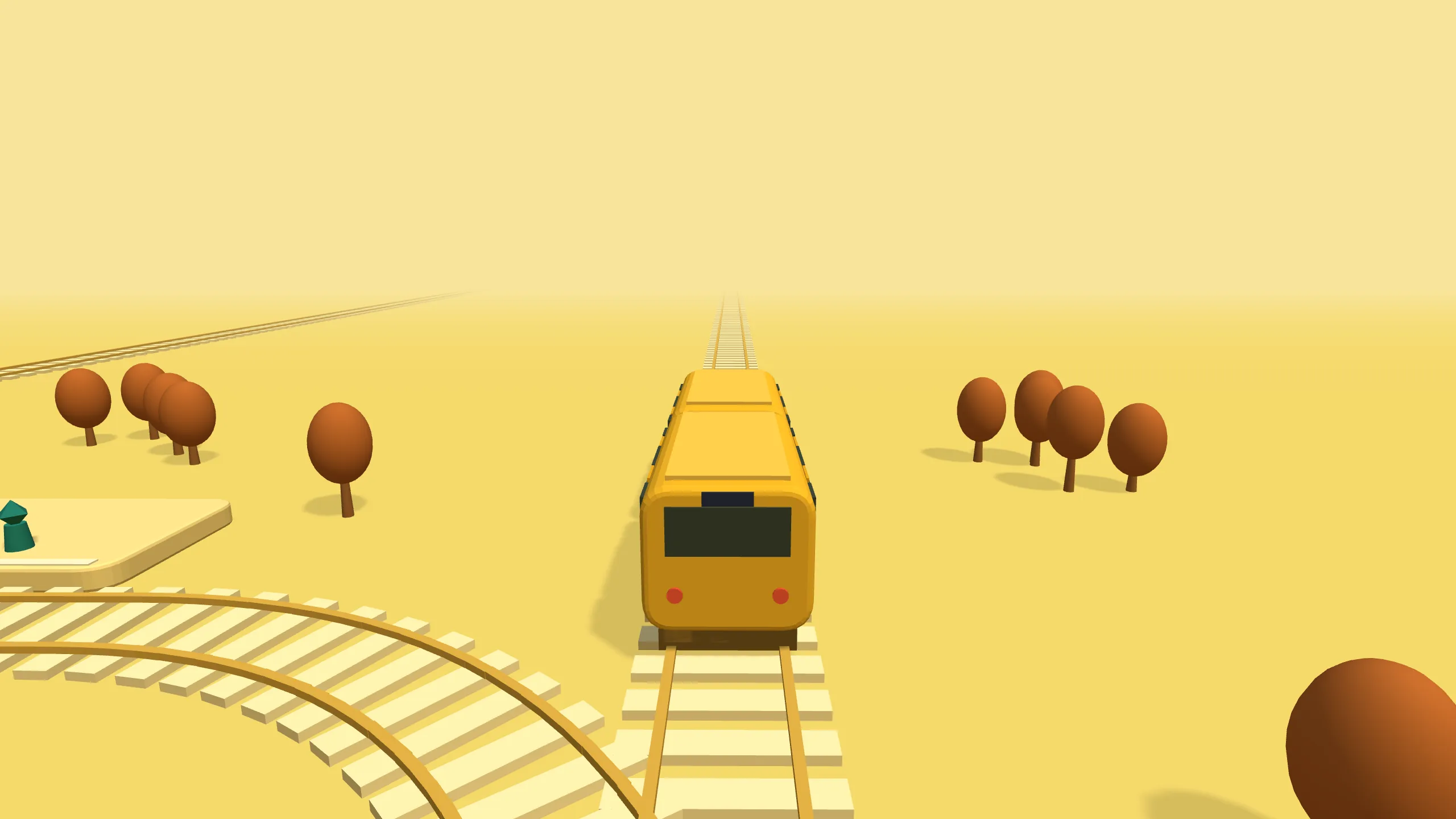 A yellow intercity train heads out of the city across open country.